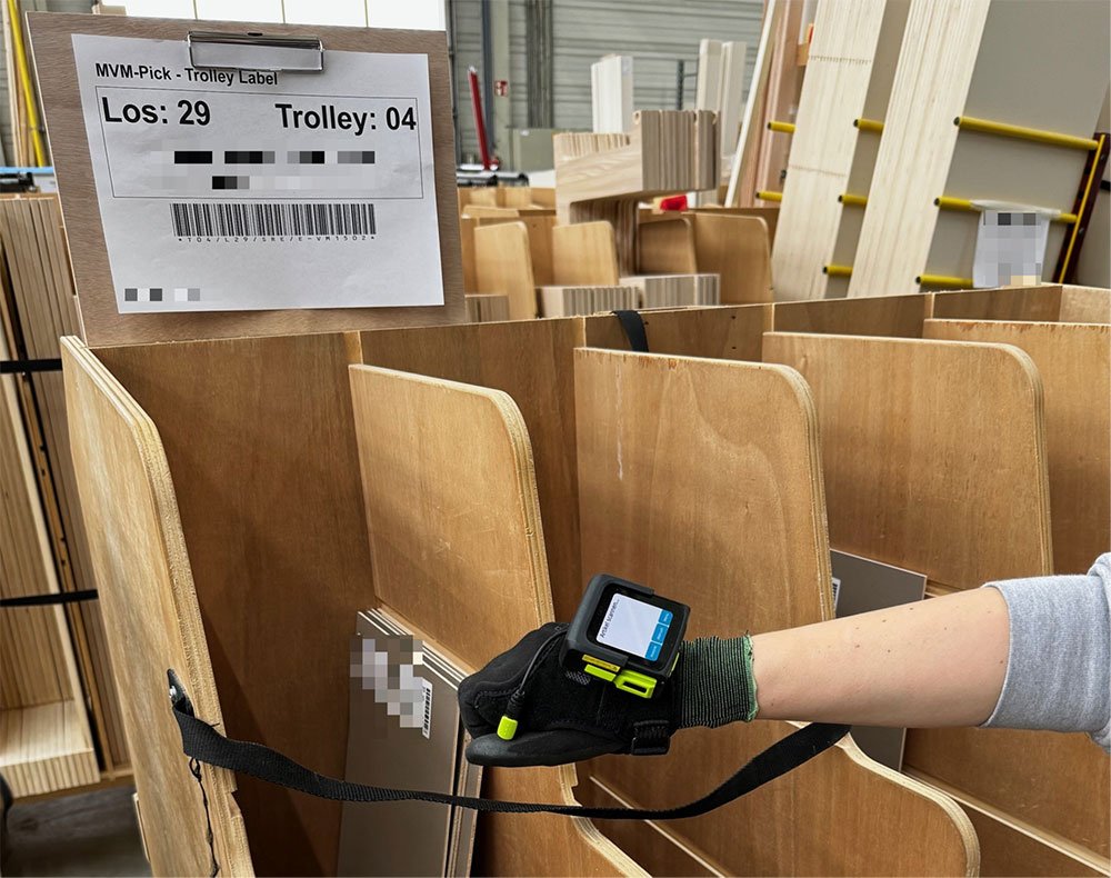 Produktionshalle mit kommissionierten Trolleys voller Möbelteile